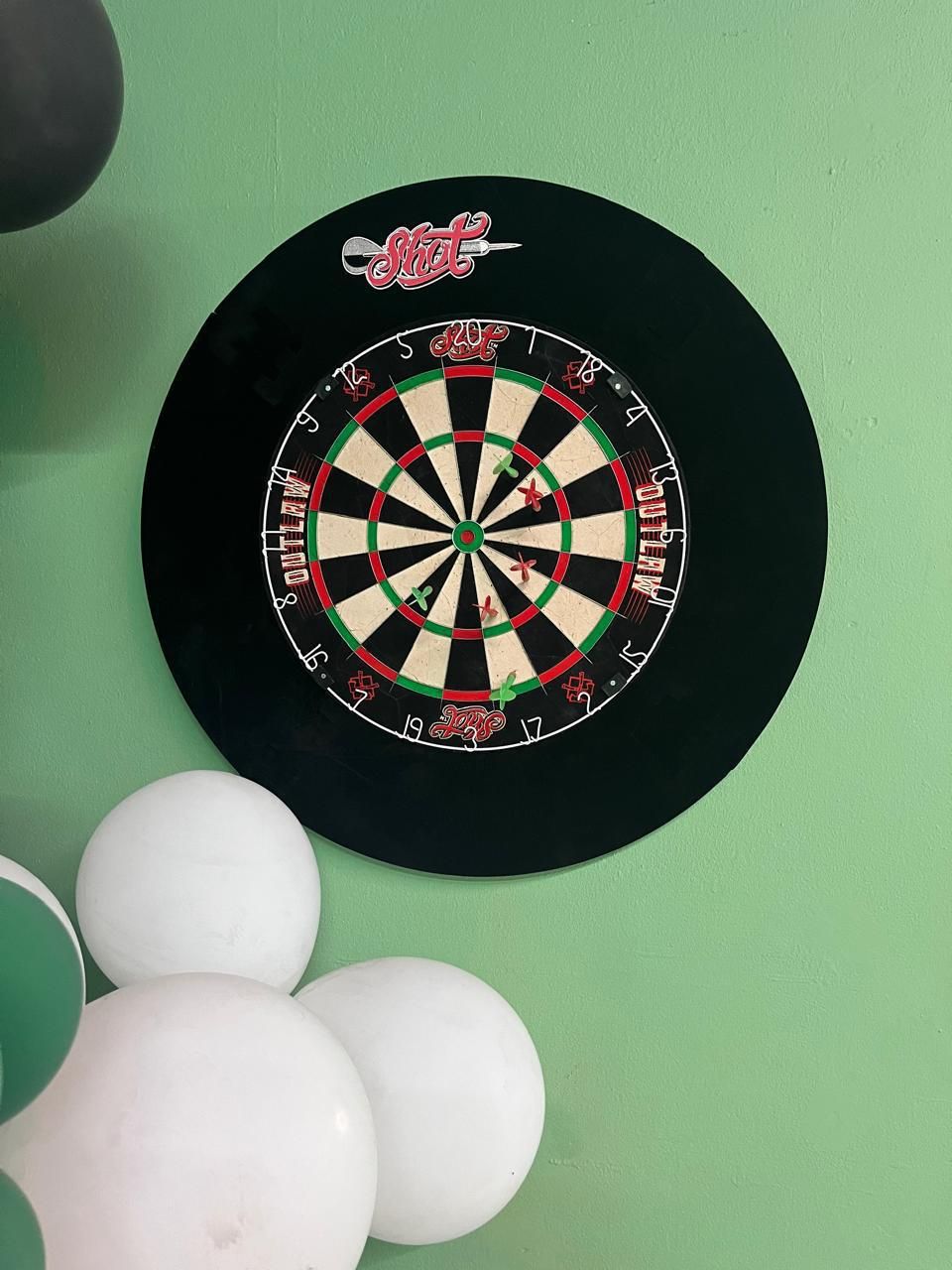 Dartboard on the mint green wall at Niacanna social club